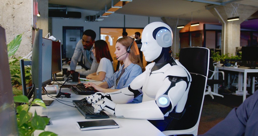 Robot,Working,At,Computer,Among,People.,Maschine,Typing,On,Keyboard